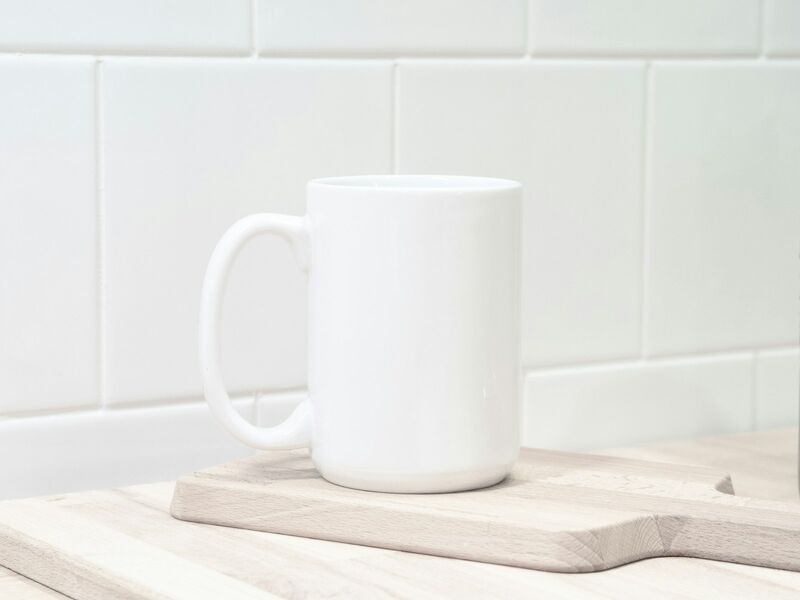 Plain white ceramic mug on a wooden board